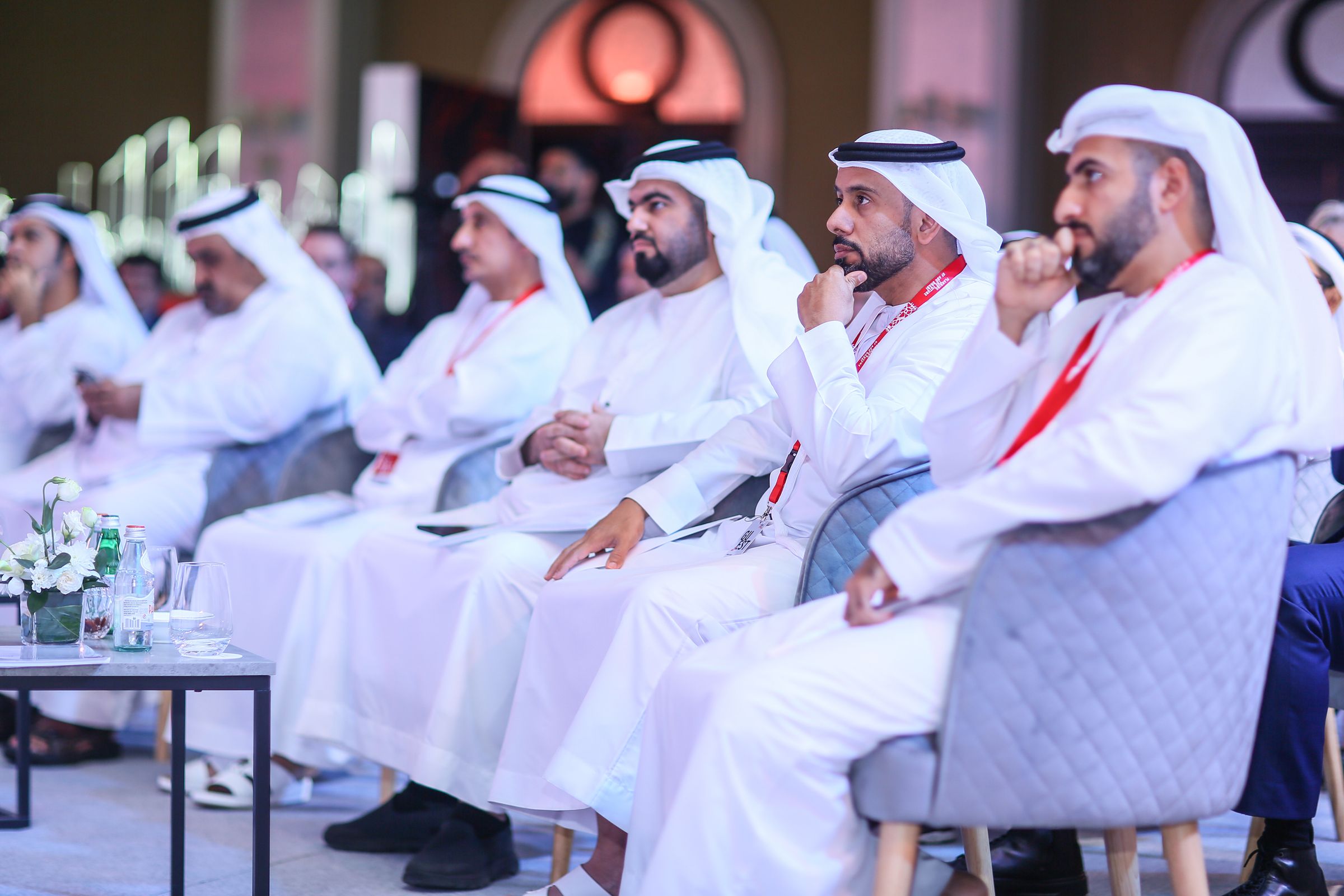 Emirati executives in a formal gathering — the room is watching, and the clock is running