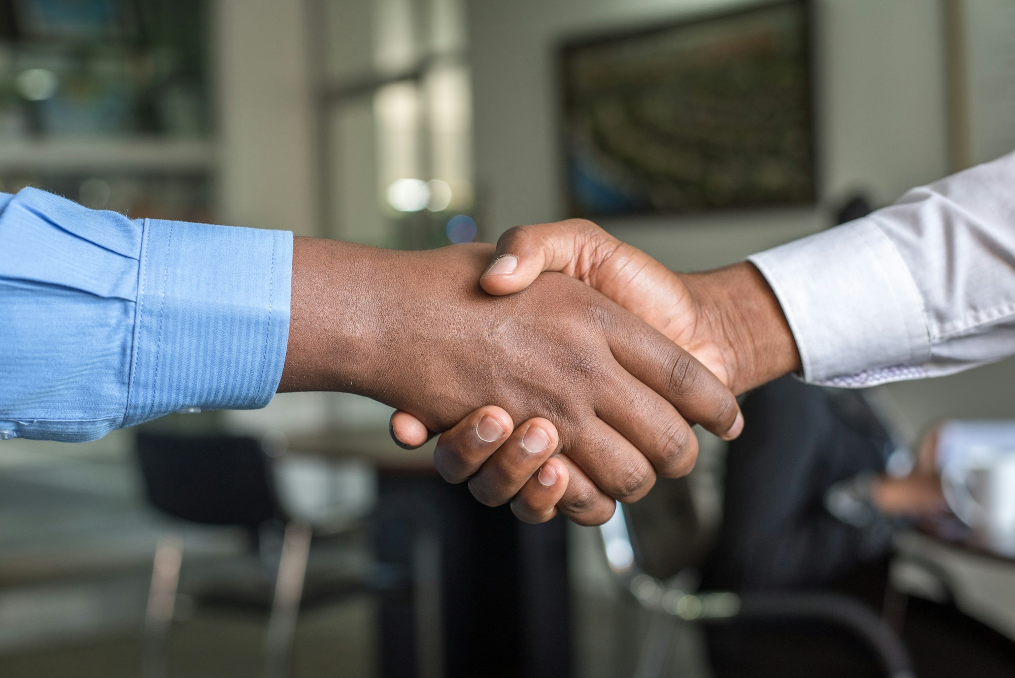 A handshake in an office — influence is earned in the first conversations, not conferred by the title