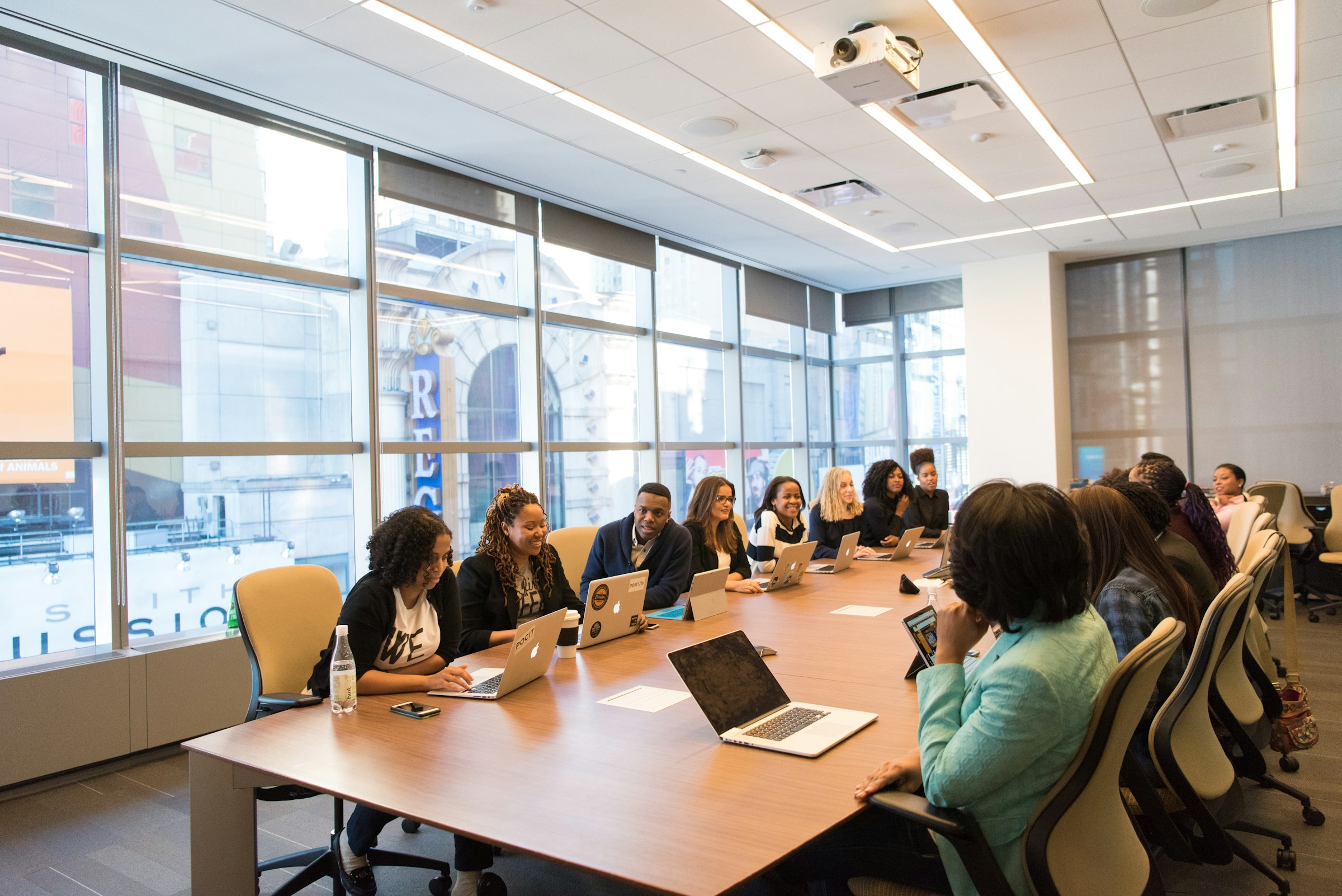 Women and colleagues around a conference table. The chair is filled. The context is not.